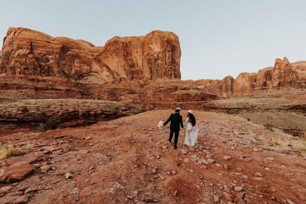 Couple walking around the Moab landscape after eloping in the Moab desert. 
