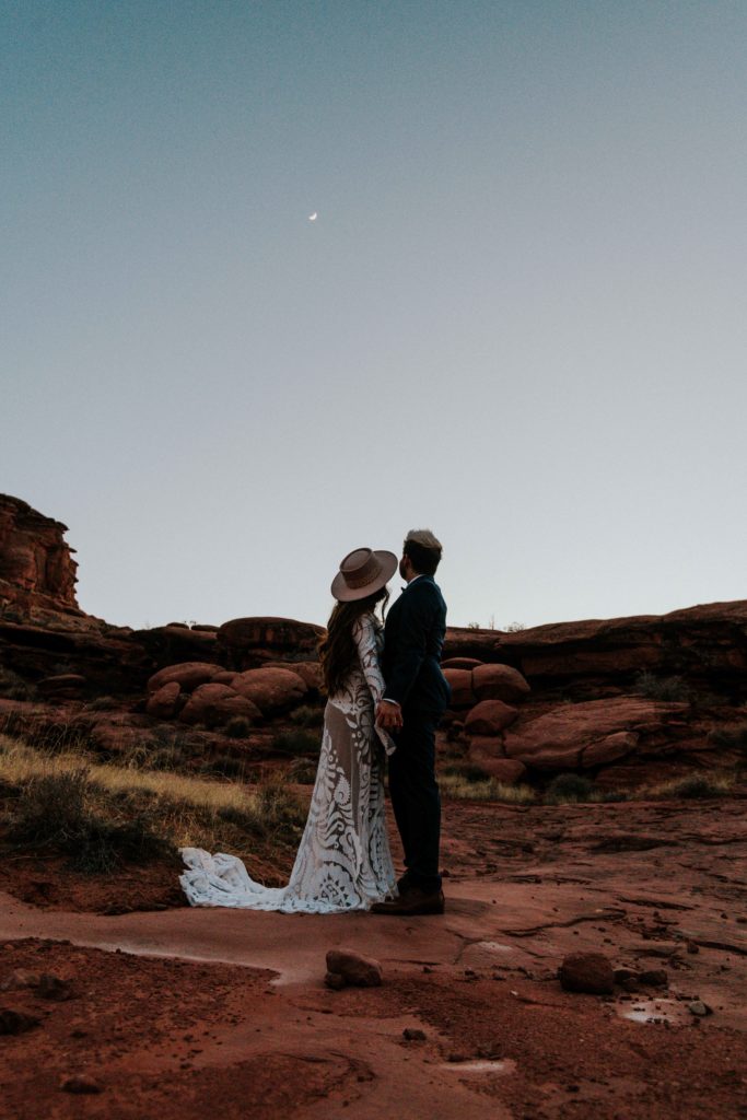 Couple enjoying the view of the moon after their elopement in Moab Utah