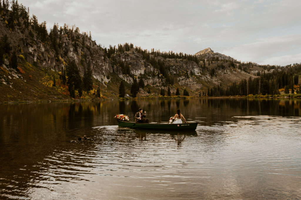 Bride & Groom canoeing on a high-alpine lake in the Utah Mountains for their elopement
