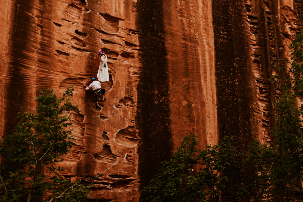 Bride & Groom Rock Climbing in Zion National Park on Namaste Wall as part of their elopement 
